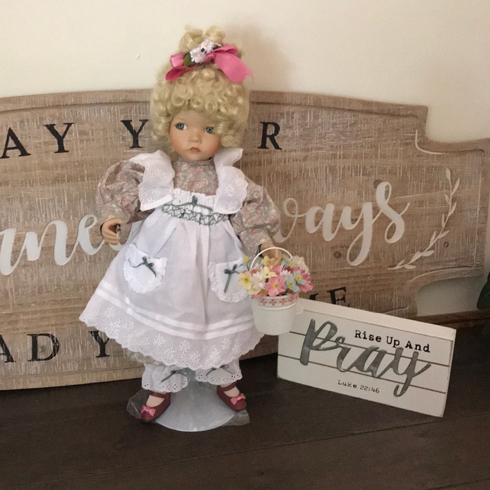 Porcelain doll with a pale of flowers